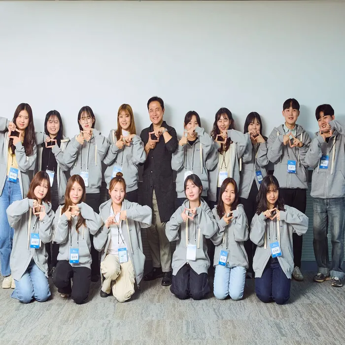 Group photo with students after a CMK Foundation lecture, everyone making a square with their fingers
